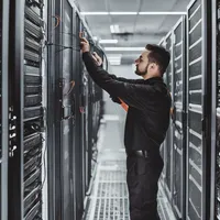 A data center technician maintaining server racks